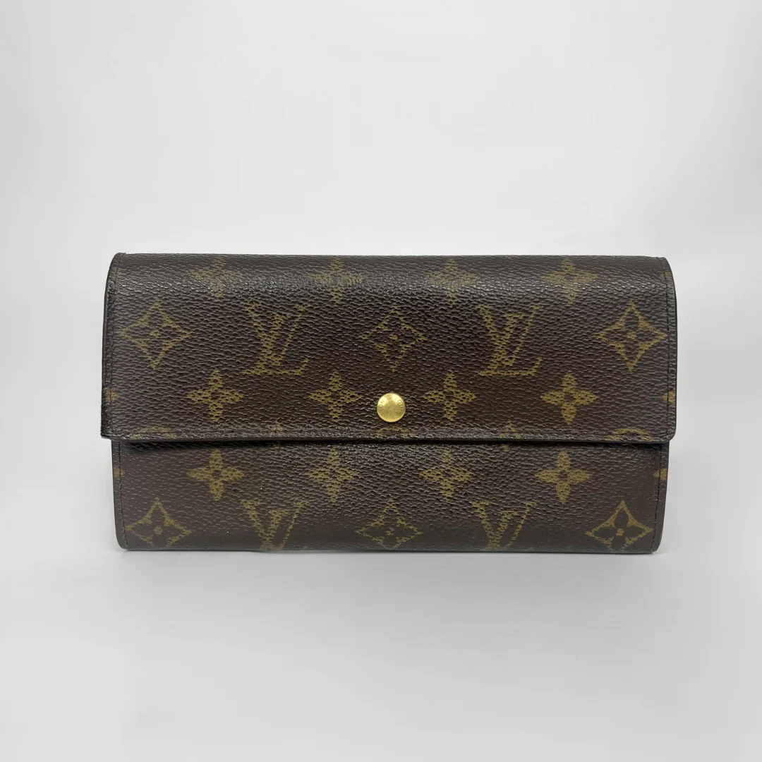 Louis Vuitton wallet with monogram pattern on a white background