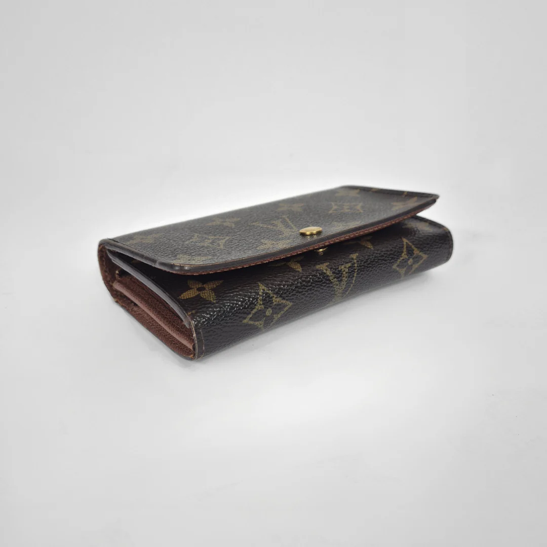 Vintage Louis Vuitton wallet with monogram pattern on a white background