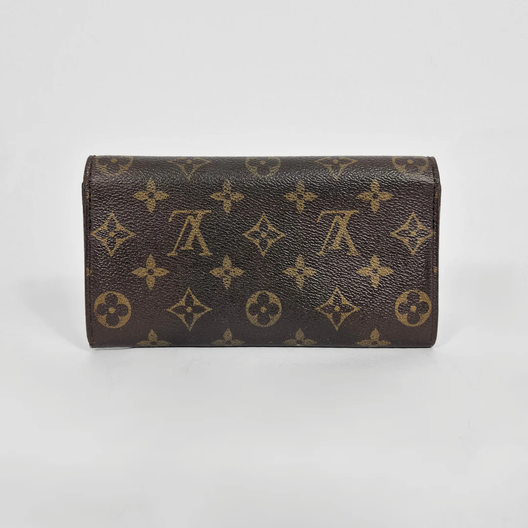 Brown wallet with monogram pattern on a light gray background