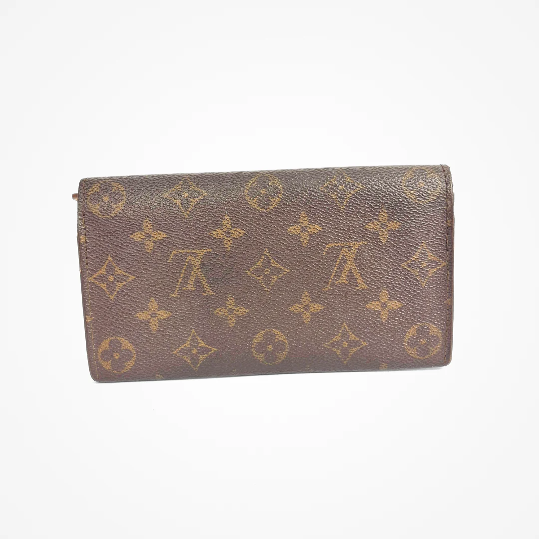 Brown LV wallet with gold monogram pattern on a white background