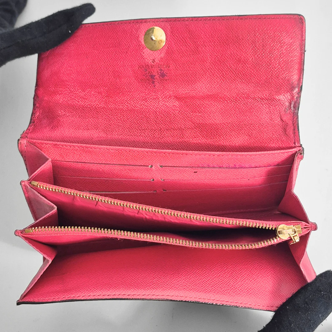 Open red wallet with gold accents on a gray background