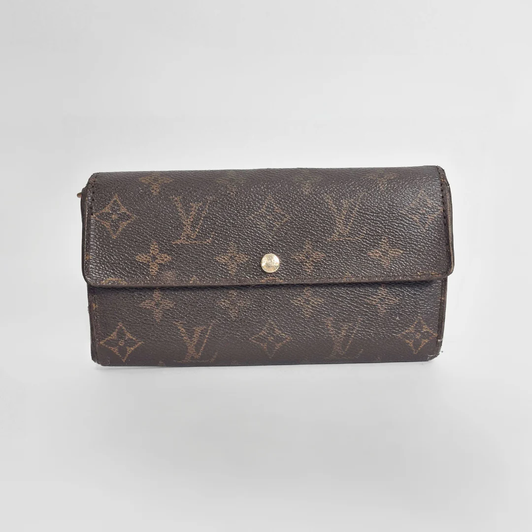 Brown wallet with monogram pattern on a light gray background