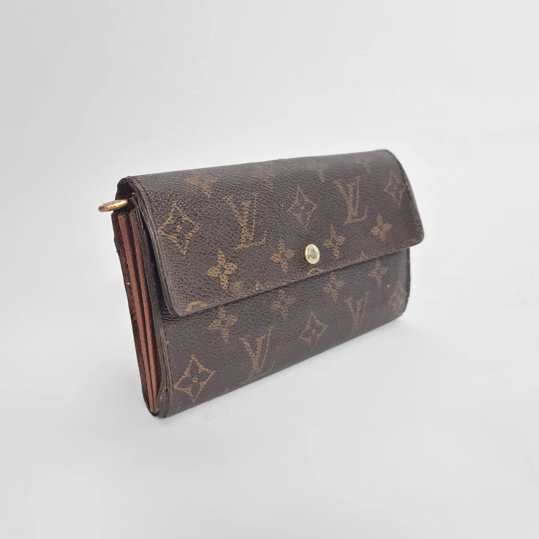 Brown wallet with monogram pattern on a light gray background