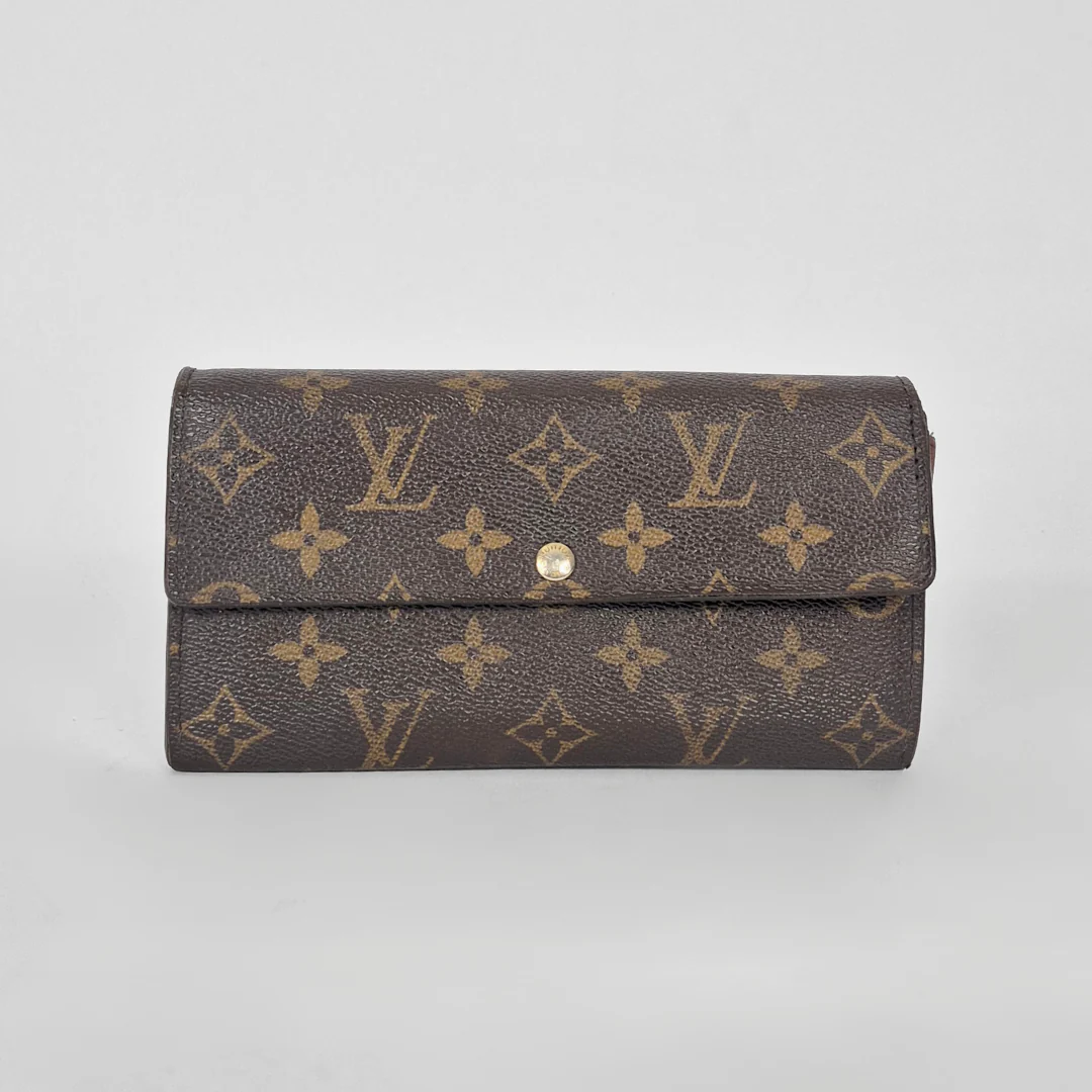 Louis Vuitton wallet with monogram pattern on a light gray background