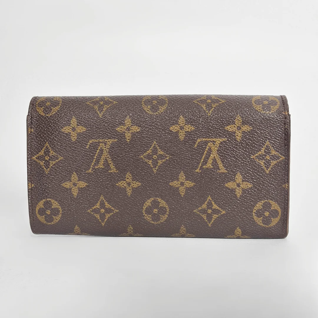 Brown wallet with gold monogram pattern on a light gray background