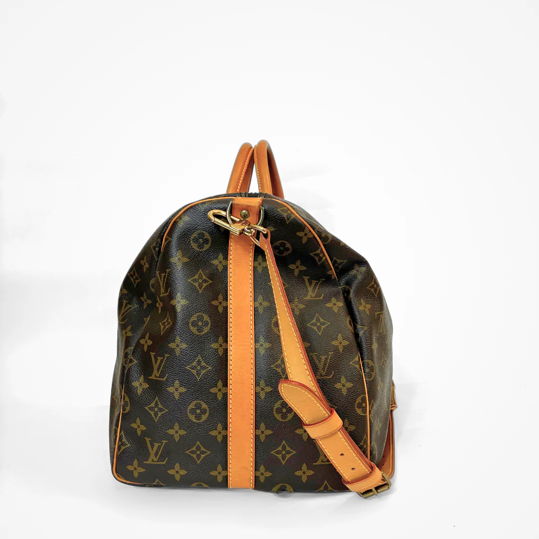 Brown LV duffel bag with monogram canvas and tan leather straps on a white background