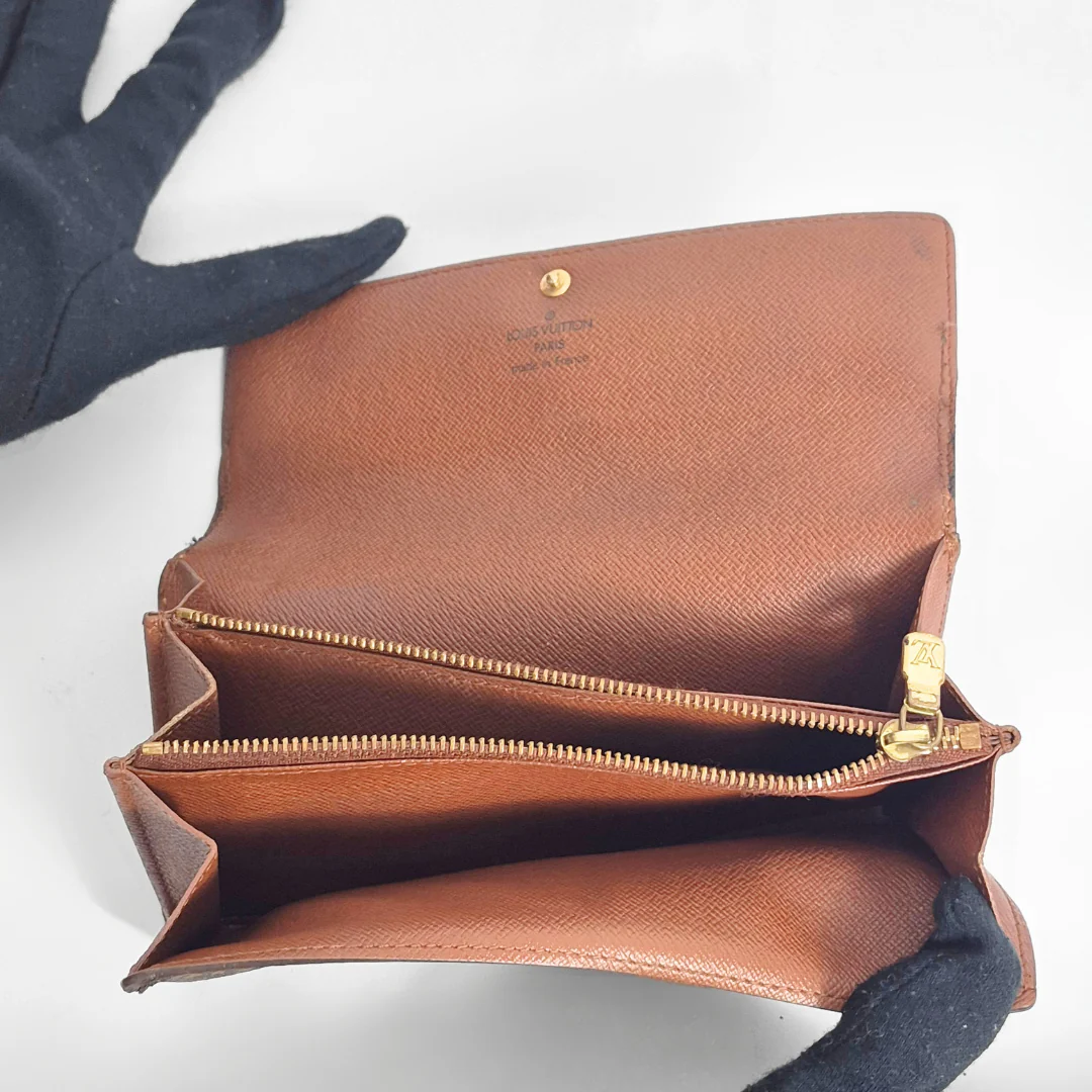 Brown leather wallet with gold zipper on a white background