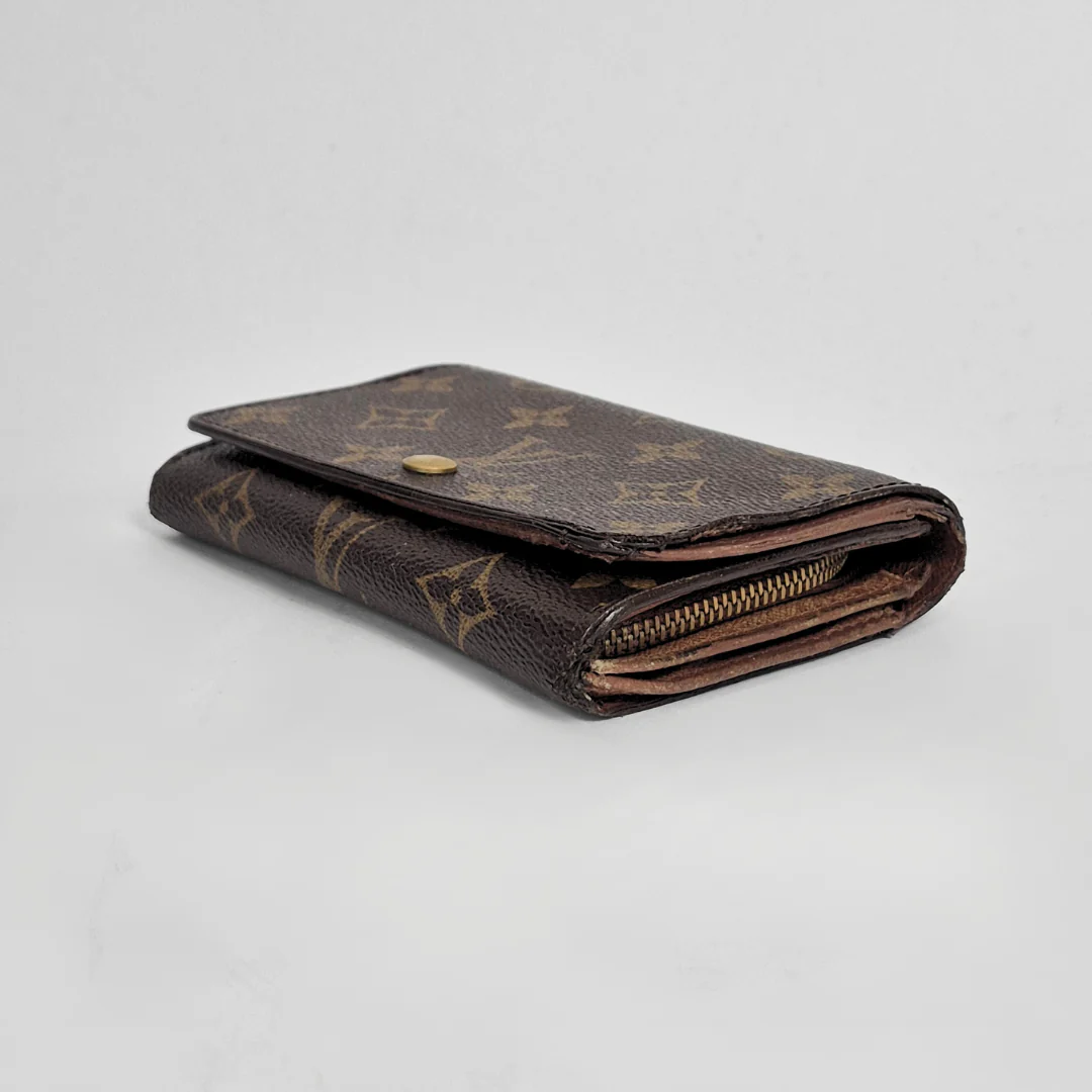 Louis Vuitton wallet with monogram pattern on a light gray background