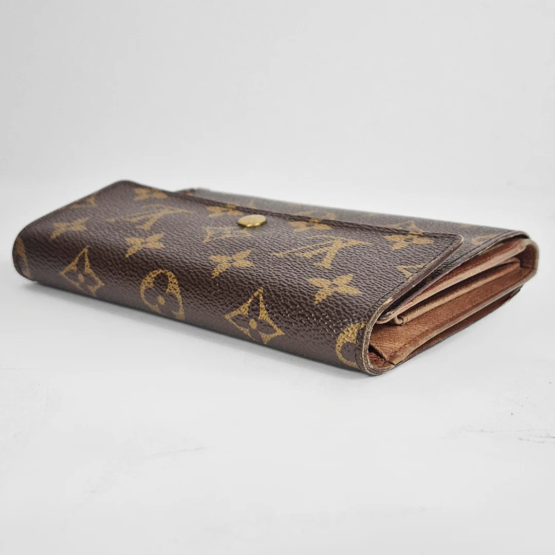 Louis Vuitton wallet with monogram pattern on a white background
