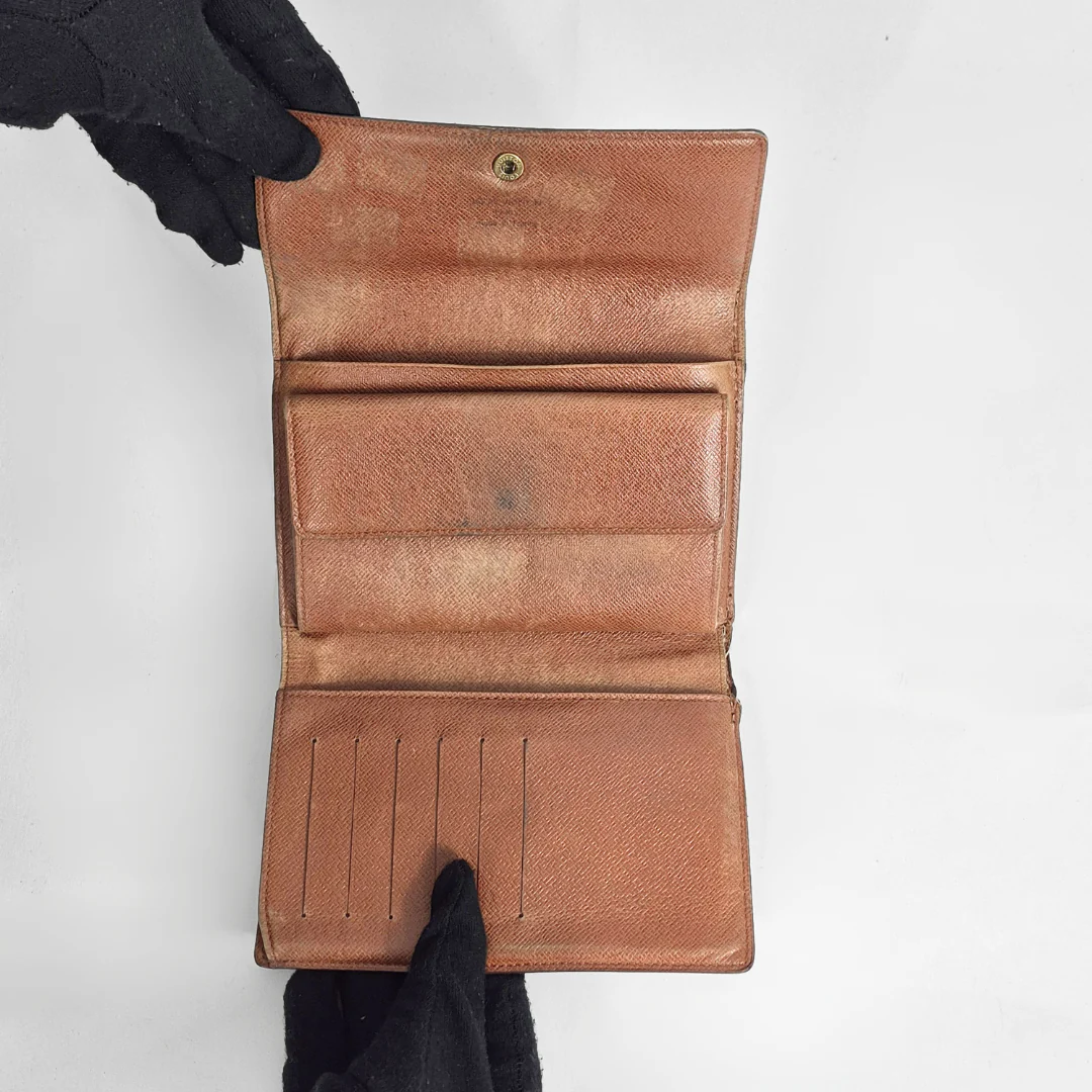 Louis Vuitton wallet with monogram pattern on a white background