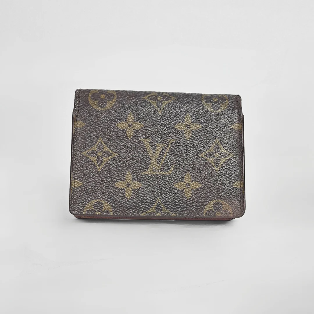 Louis Vuitton wallet with monogram pattern on a light gray background