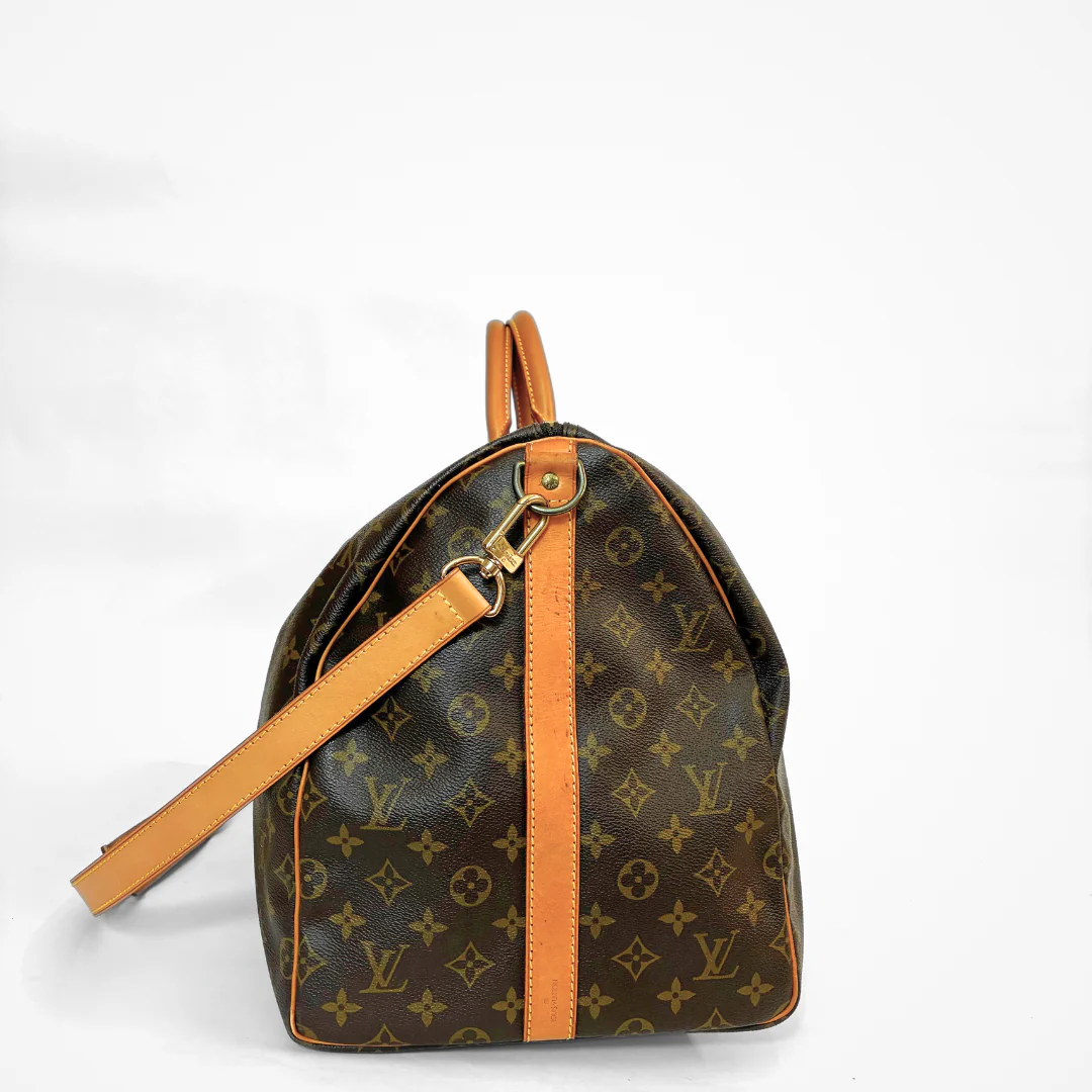 Brown LV duffel bag with monogram canvas and tan leather straps on a white background