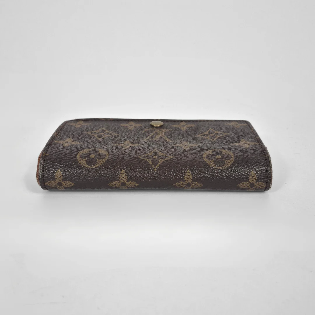Louis Vuitton wallet with monogram pattern on a white background