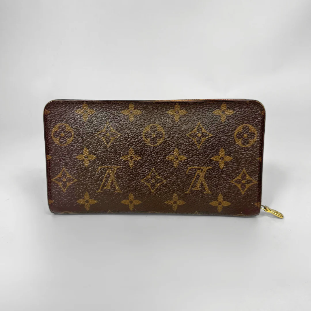 Brown wallet with gold monogram pattern on a white background