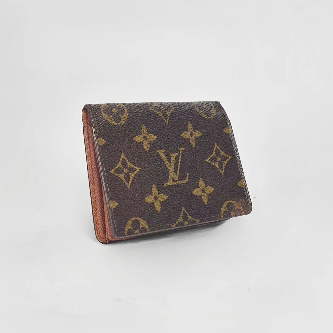 Louis Vuitton wallet with monogram pattern on a light gray background