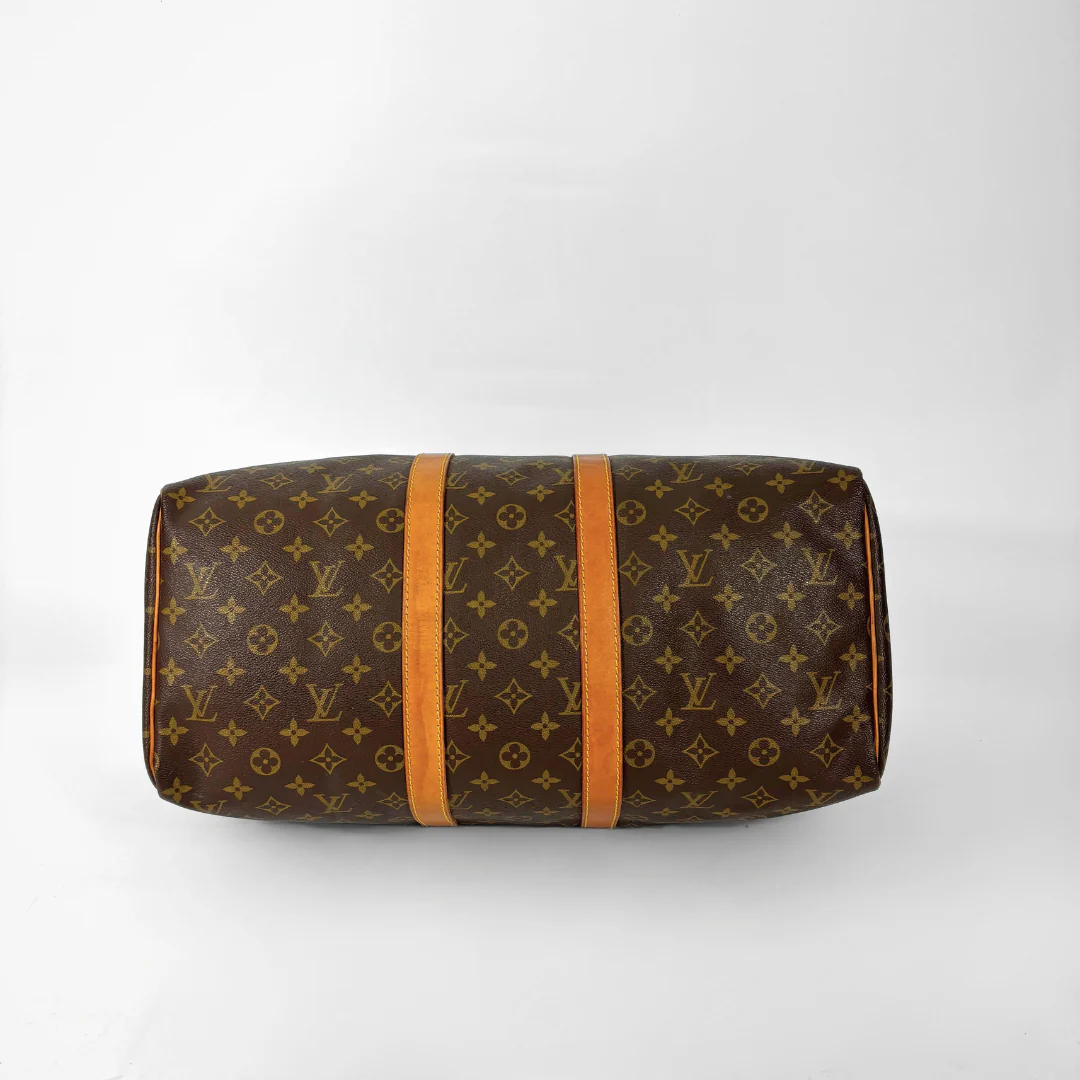 Brown monogram patterned bag with orange straps on a white background
