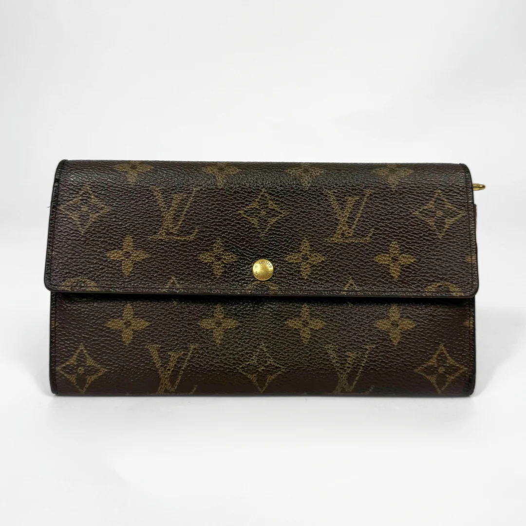 Brown leather wallet with gold monogram pattern on a white background
