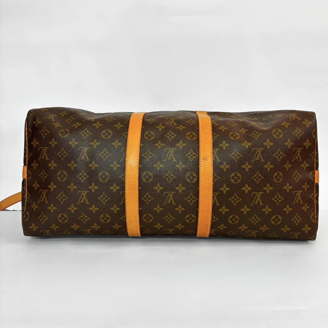 Brown LV duffel bag with monogram canvas and tan leather straps on a white background