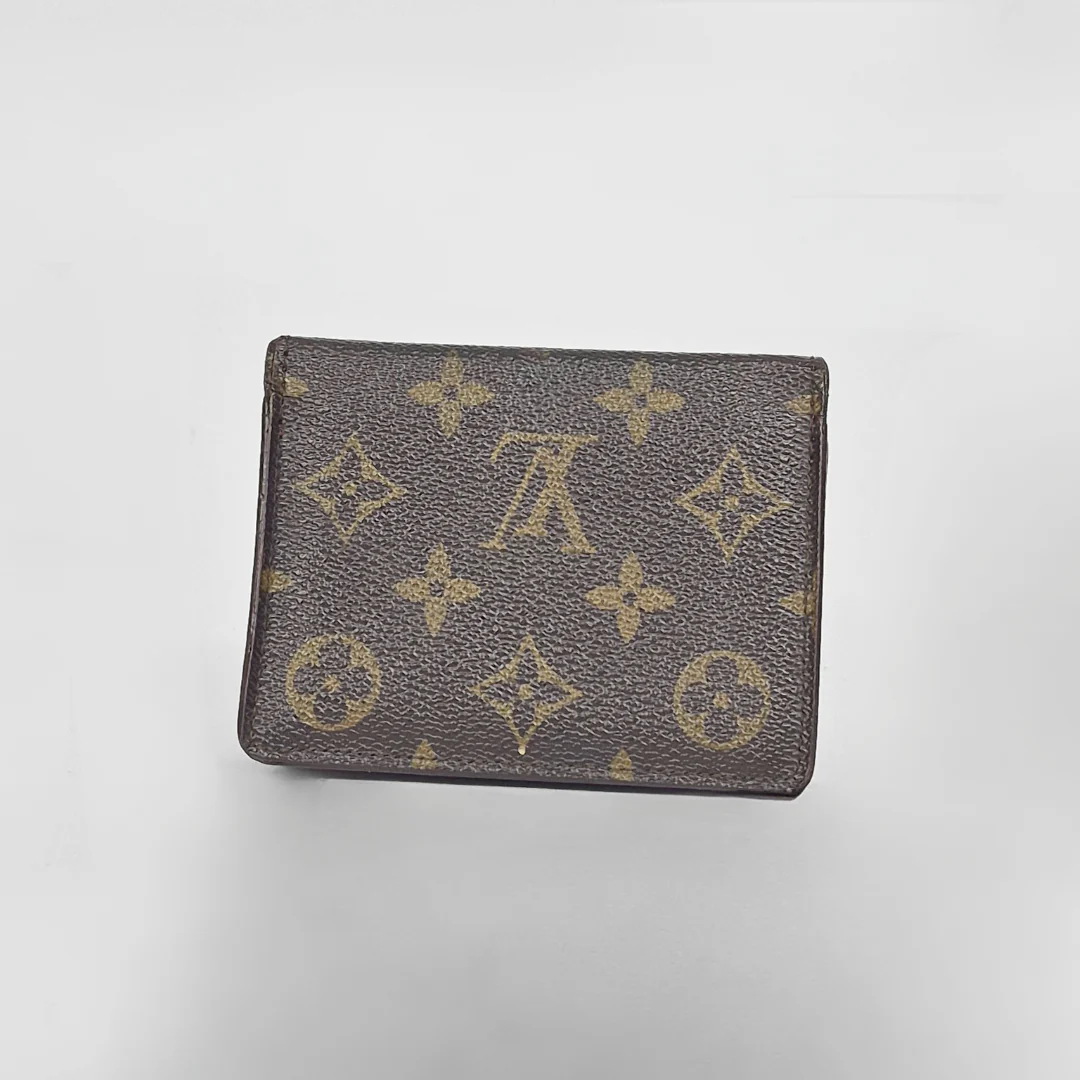 Louis Vuitton wallet with monogram pattern on a light gray background