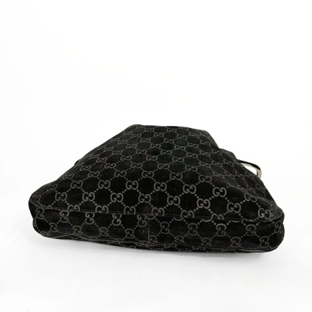 Gucci GG black suede shoulder bag on a white background