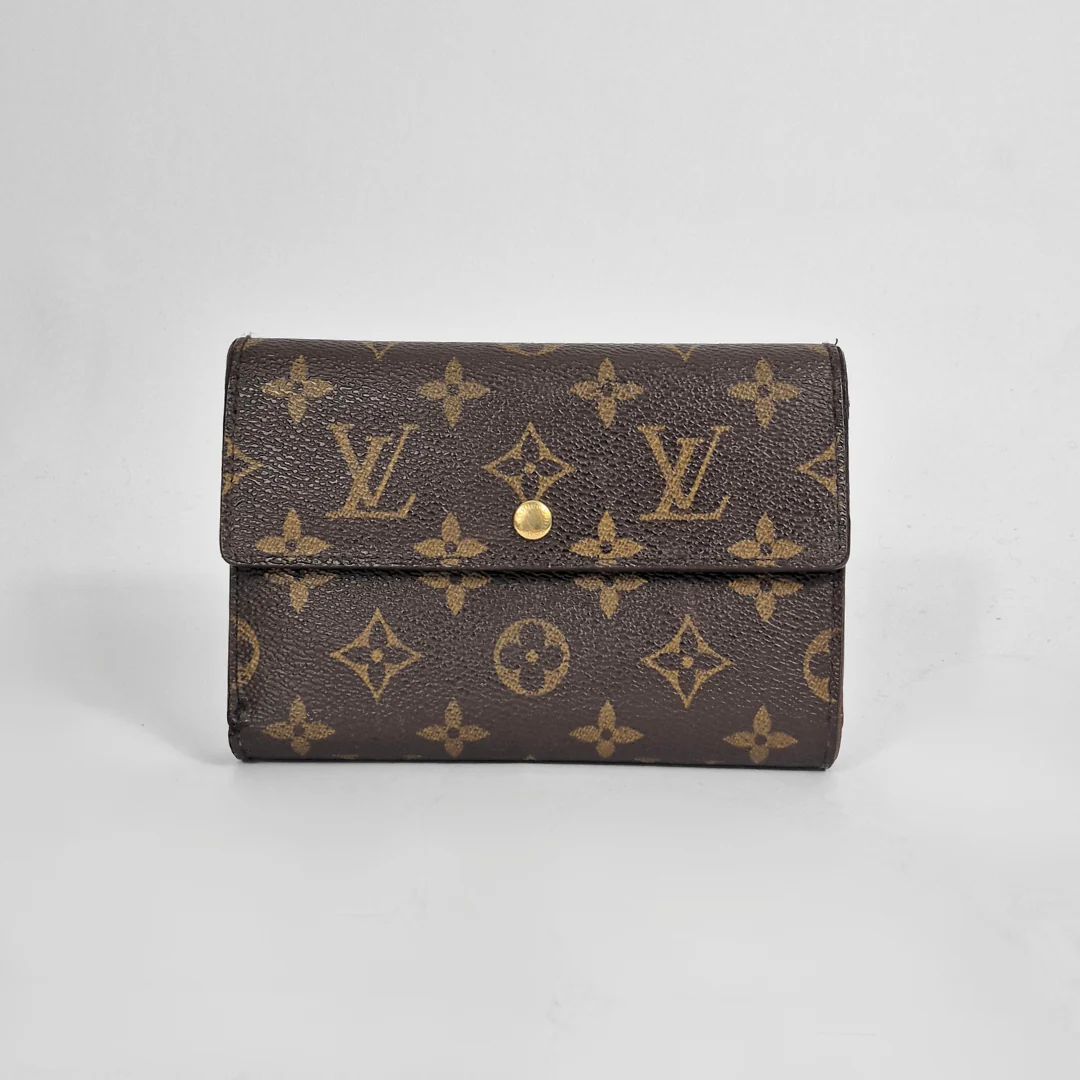 Louis Vuitton wallet with monogram pattern on a light gray background