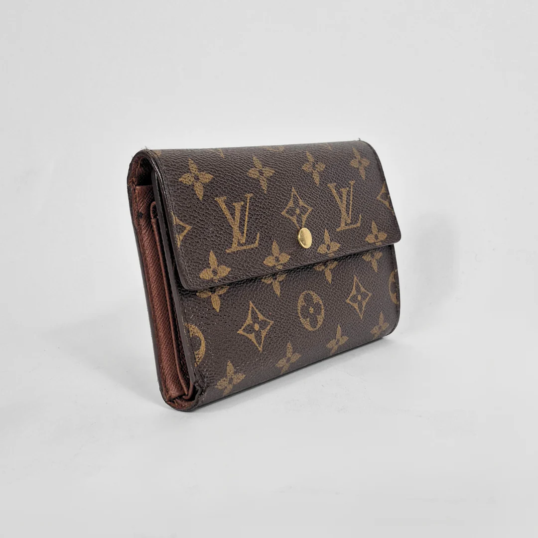 Louis Vuitton wallet with monogram pattern on a light gray background