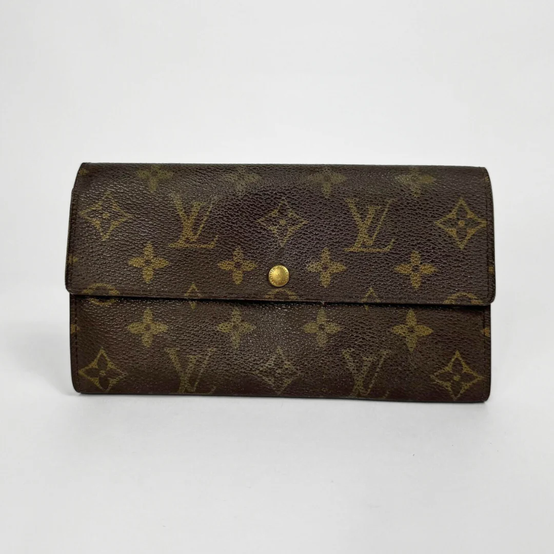 Brown wallet with gold monogram pattern on a white background