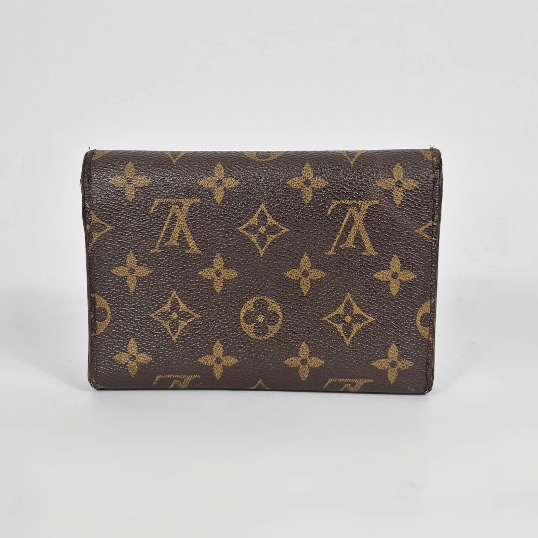 Brown wallet with gold monogram pattern on a white background
