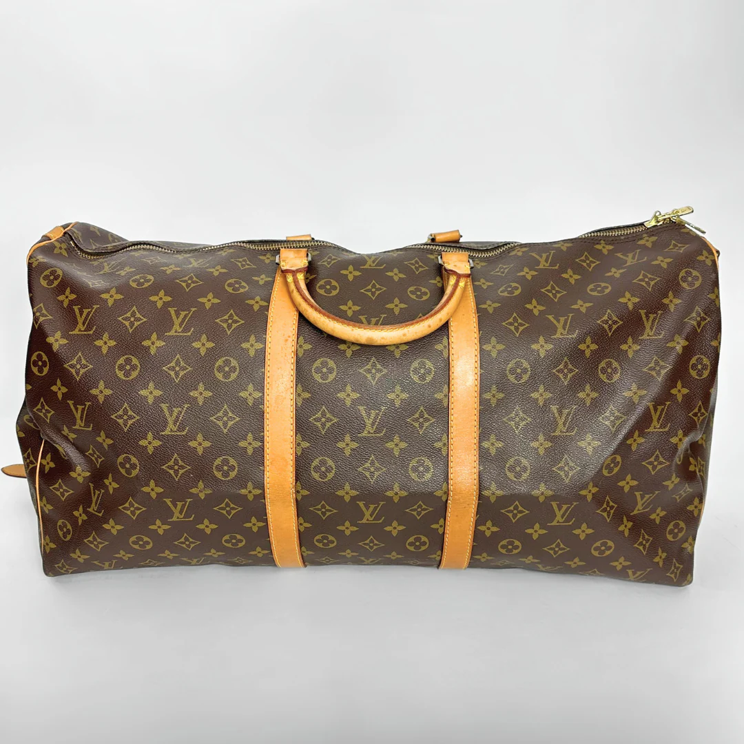 Brown travel bag with yellow monogram pattern on a white background