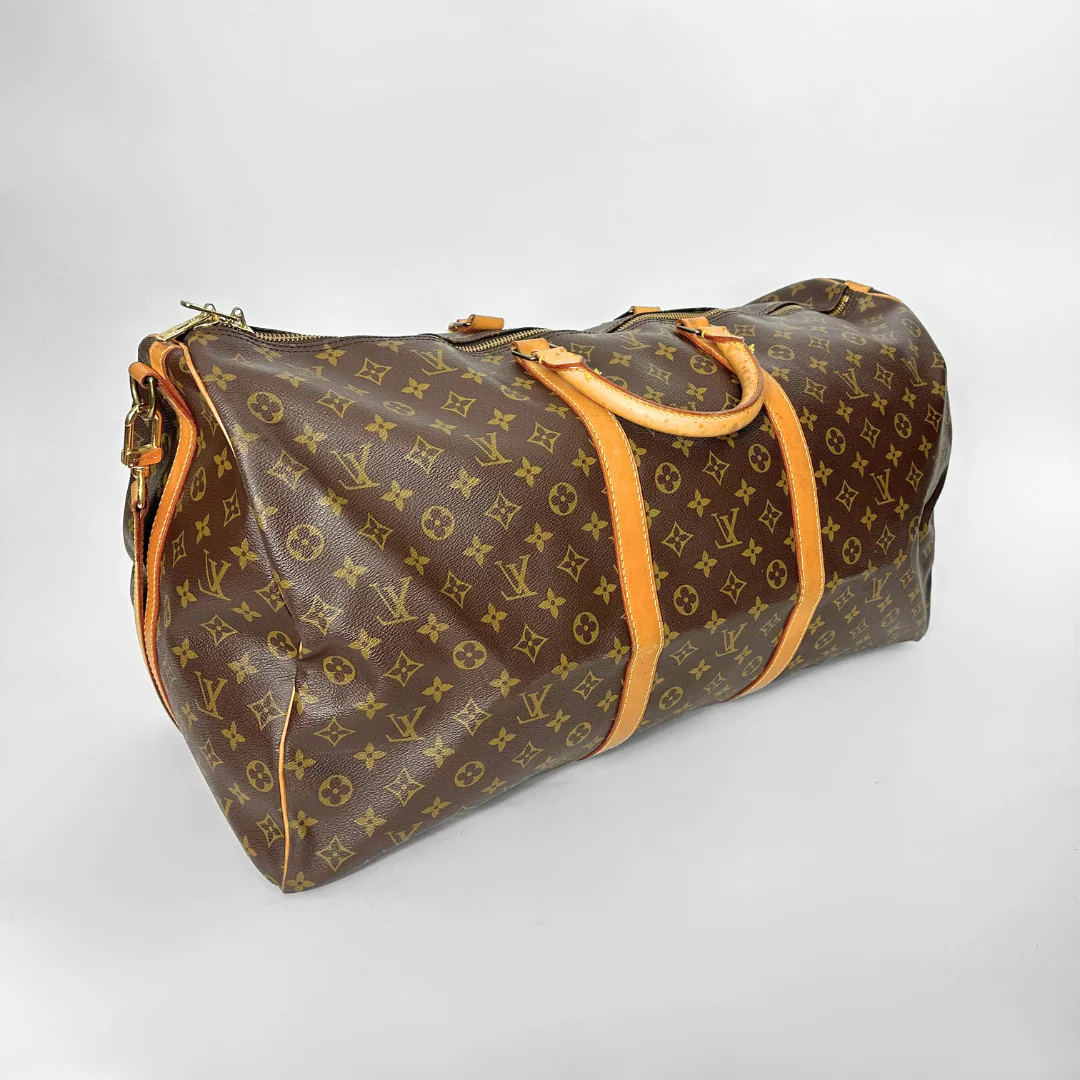 Designer travel bag with monogram pattern on a light gray background