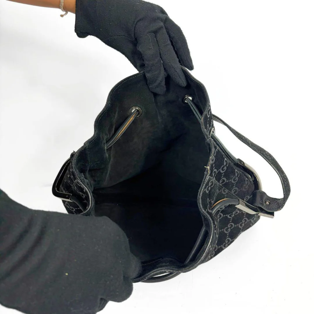 Gucci GG black suede shoulder bag on a white background
