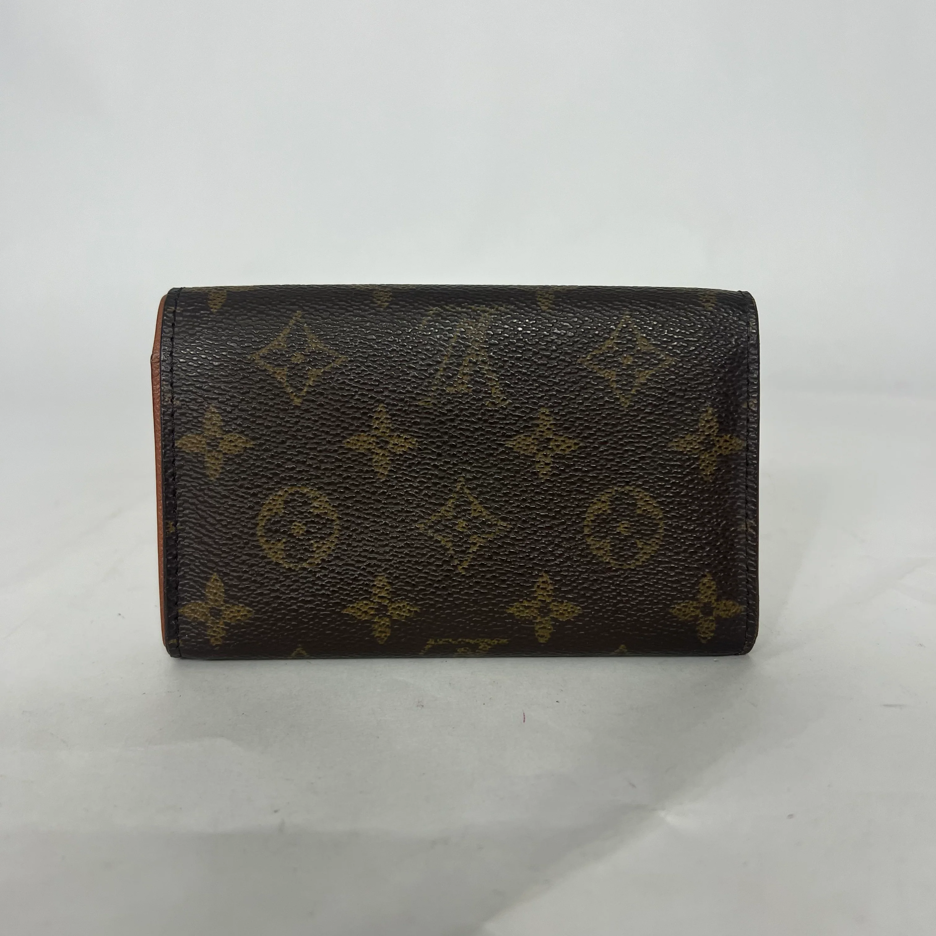 Louis Vuitton wallet with monogram pattern on a white background