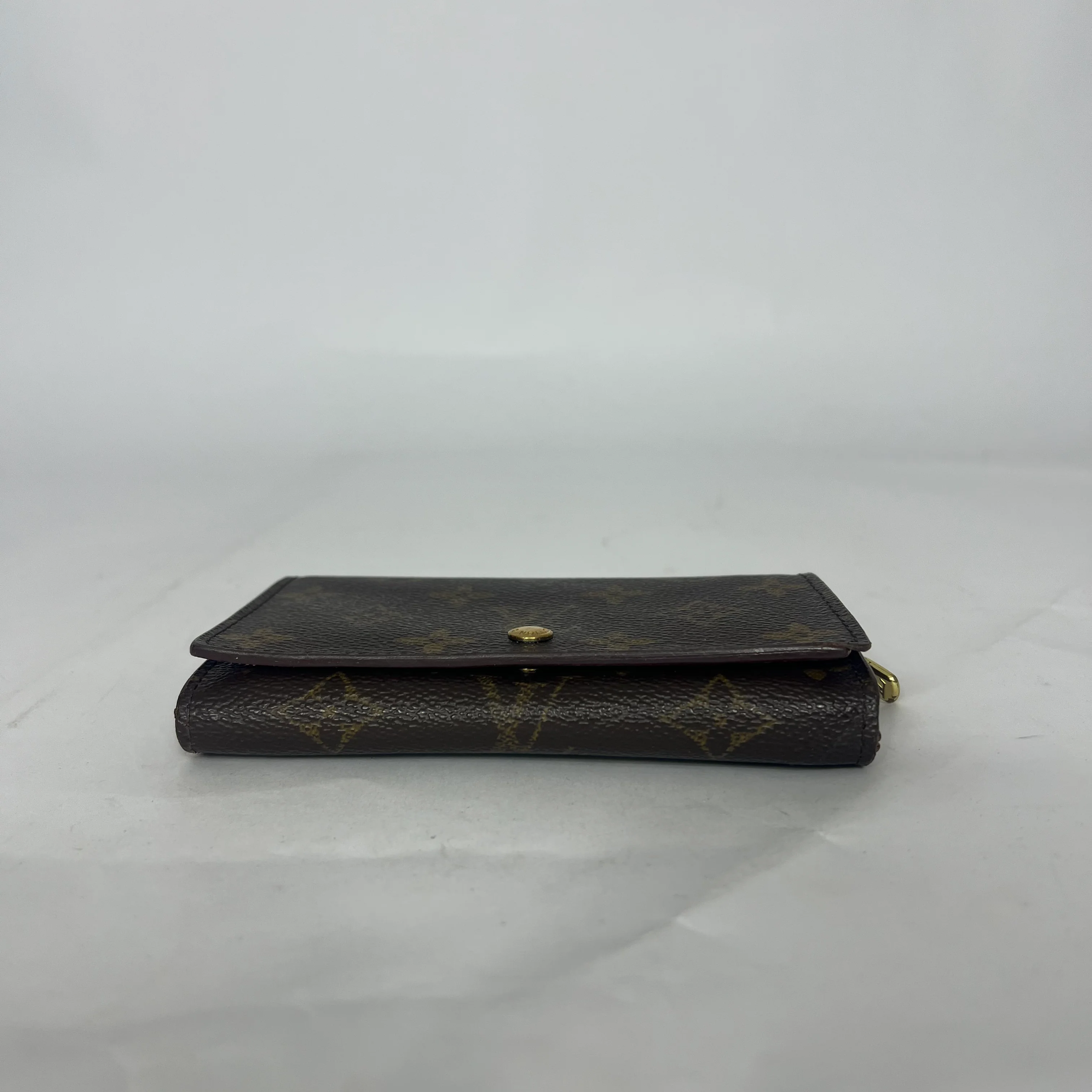 Black leather wallet with gold accents on a white background