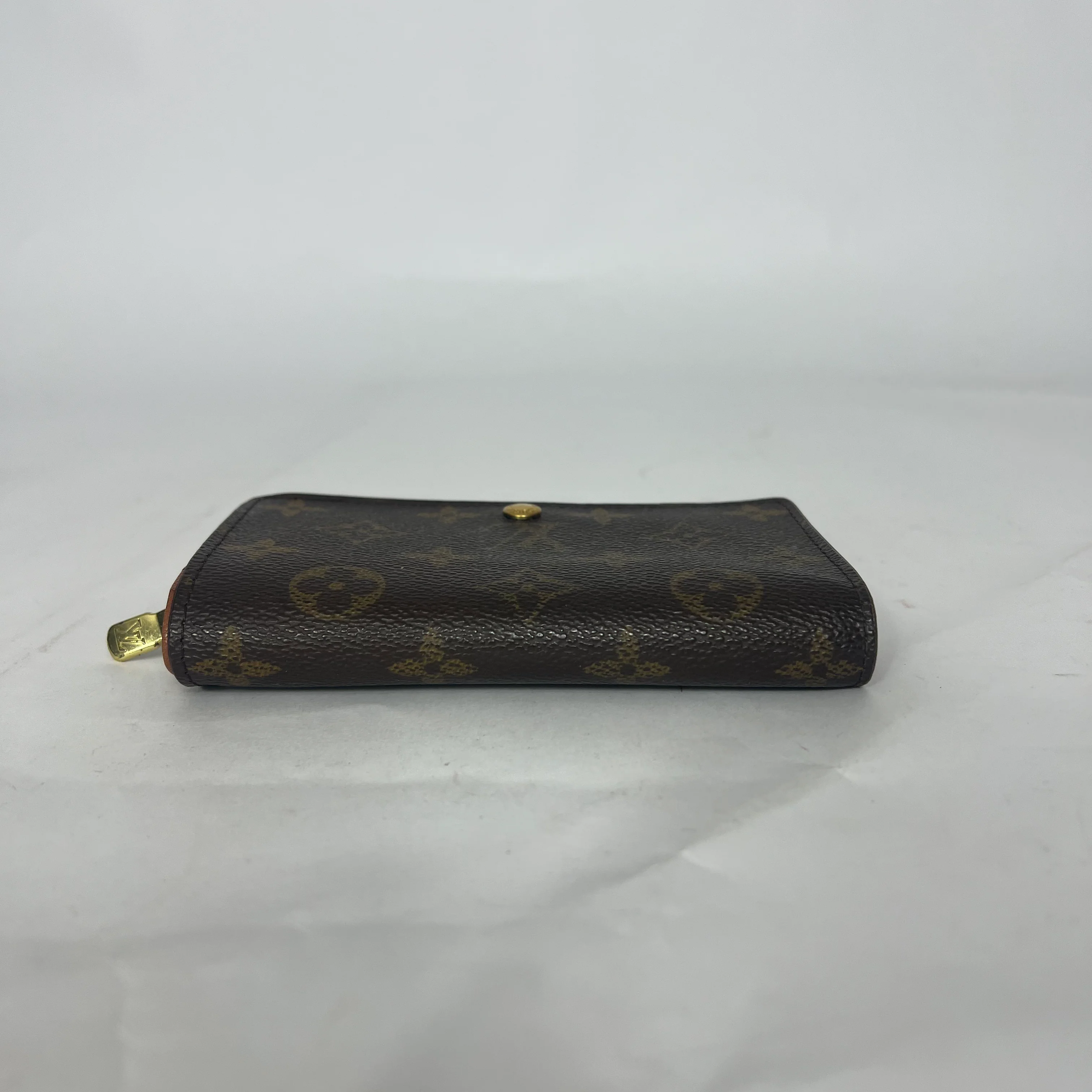 Black leather wallet with gold accents on a white background