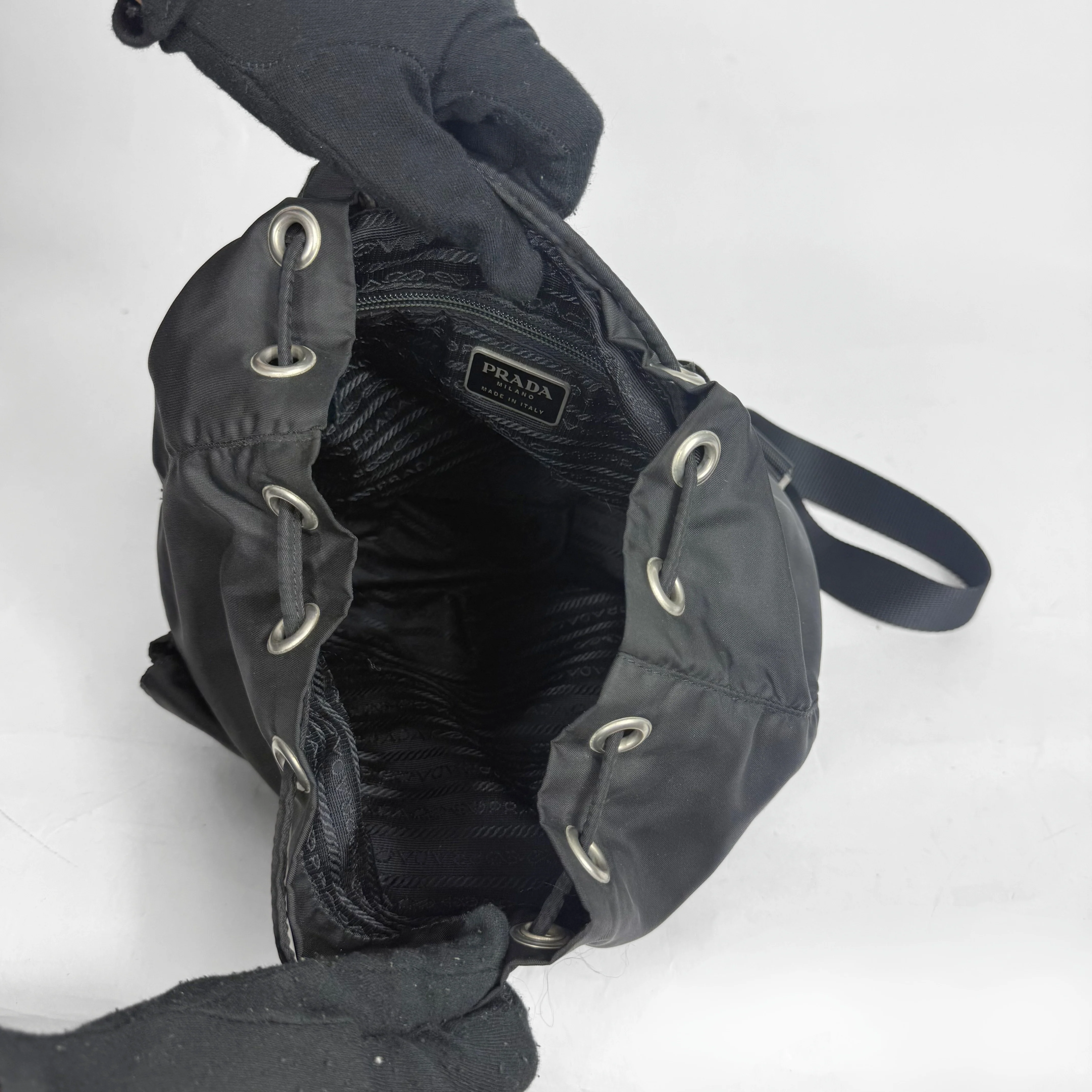 Black Prada handbag with drawstring closure on a white background